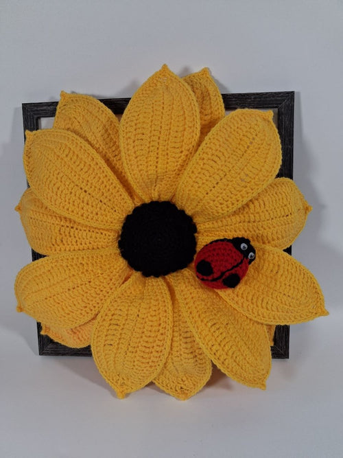 Large yellow crochet sunflower with a detachable red ladybird in a dark wooden frame