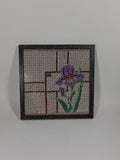 Hand-embroidered purple iris on patterned cotton canvas in a dark wooden frame